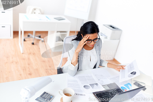 Image of businesswoman with laptop working at office