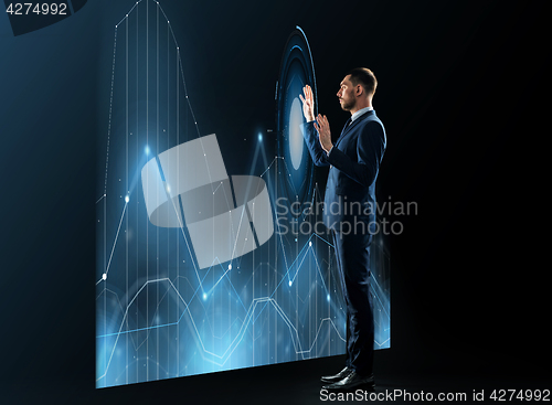 Image of businessman working with virtual chatrs projection