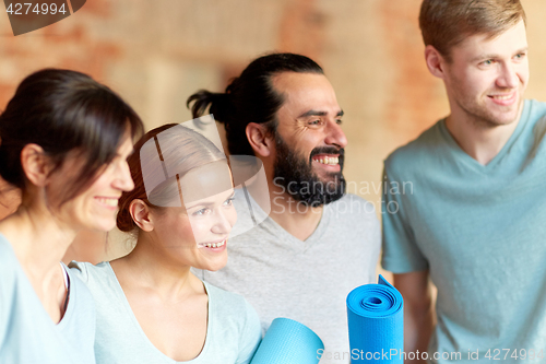 Image of group of people with mats at yoga studio or gym