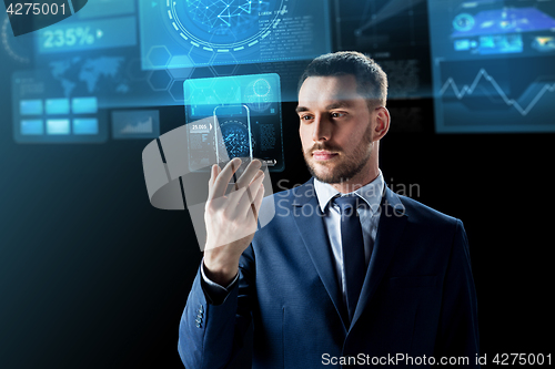 Image of businessman with smartphone and virtual screens