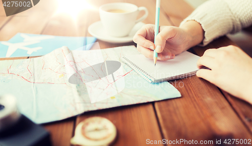 Image of close up of traveler hands with notepad and pencil