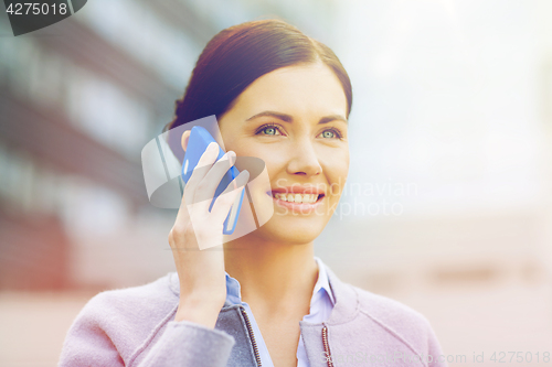 Image of young smiling businesswoman calling on smartphone