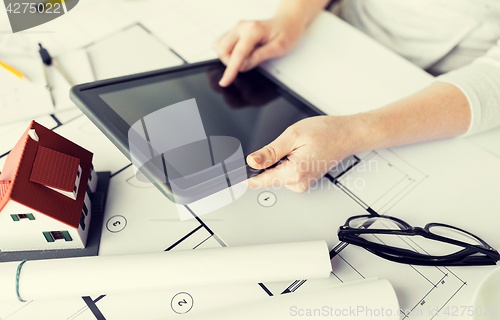 Image of close up of hand with blueprint and tablet pc