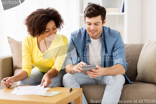 Image of happy couple with papers and calculator at home