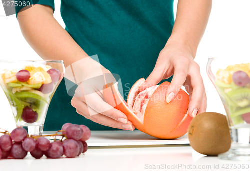 Image of Cook is peeling grapefruit for fruit dessert