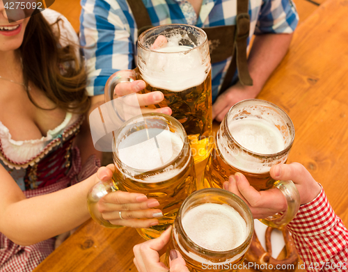 Image of Young couple toasting in Oktoberfest beer tent