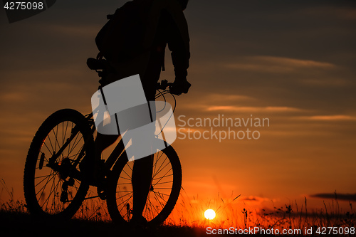 Image of Silhouette of a bike on sky background during sunset