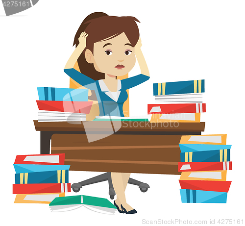 Image of Student sitting at the table with piles of books.