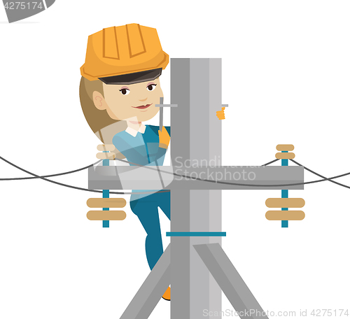 Image of Electrician working on electric power pole.