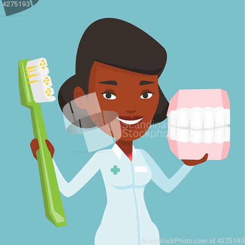 Image of Dentist with dental jaw model and toothbrush.