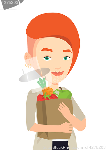 Image of Happy woman holding grocery shopping bag.