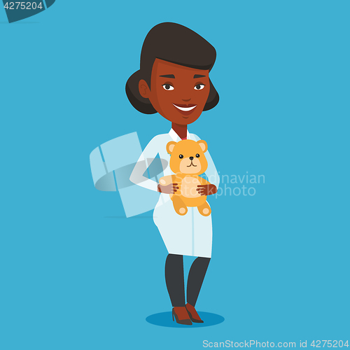 Image of Pediatrician doctor holding teddy bear.