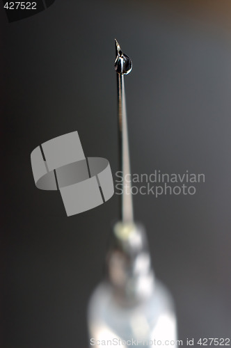 Image of syringe close-up, focus on the drop