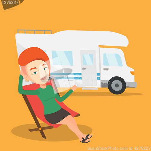 Image of Woman sitting in chair in front of camper van.