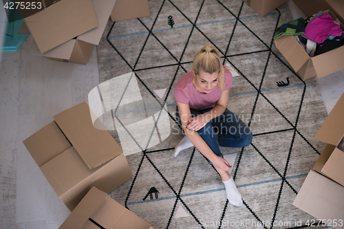 Image of top view of young beautiful woman sitting on the floor