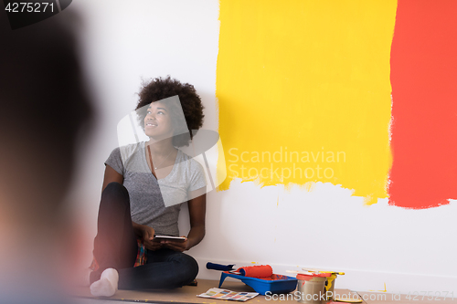Image of back female painter sitting on floor