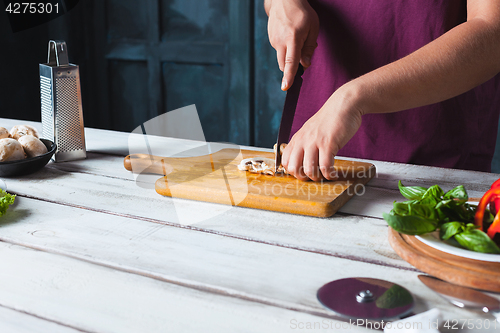 Image of Closeup hand of chef baker making pizza at kitchen