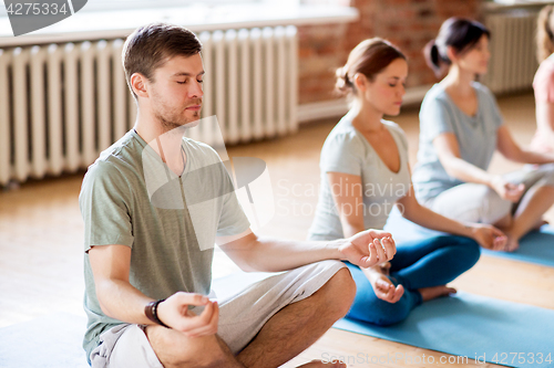 Image of group of people making yoga exercises at studio