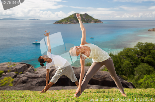 Image of happy couple doing yoga outdoors