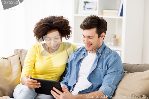 Image of smiling happy couple with tablet pc at home