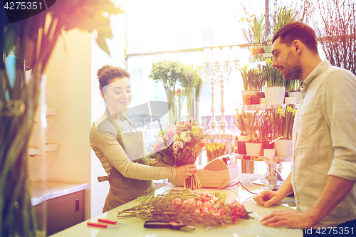 Image of smiling florist woman and man at flower shop