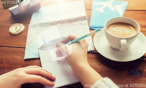 Image of close up of traveler hands with notepad and pencil