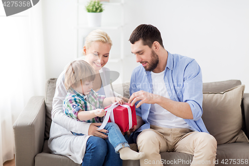 Image of happy family with birthday gift at home