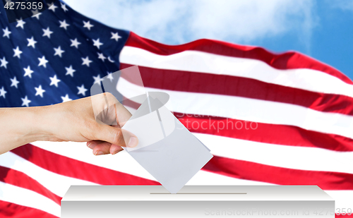 Image of hand of american with ballot and box on election