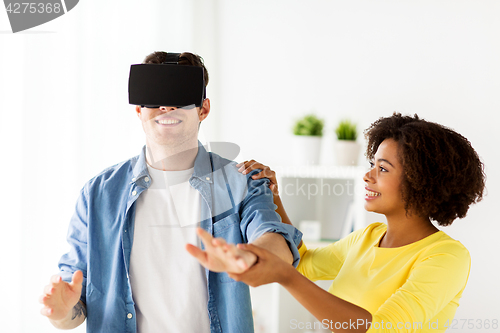 Image of happy couple with virtual reality headset at home
