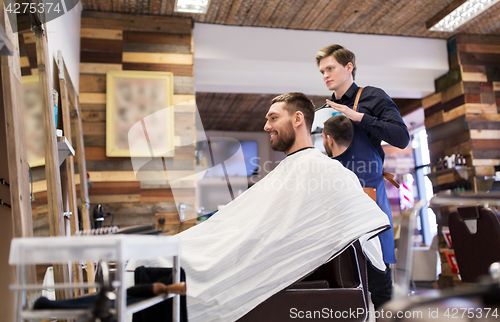 Image of man and hairdresser with mirror at barbershop