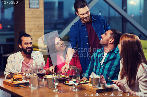Image of friends dining and drinking wine at restaurant