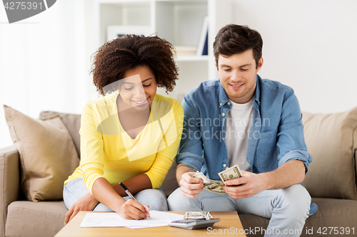 Image of happy couple with papers and calculator at home