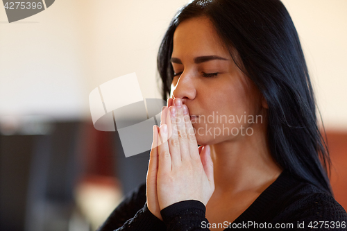 Image of close up of unhappy woman praying god at funeral