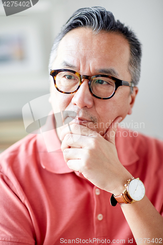 Image of asian man thinking at home