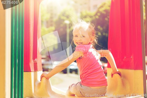 Image of happy little girl on slide at children playground