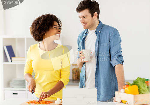 Image of happy couple cooking food at home kitchen