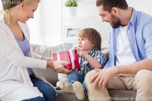 Image of happy family with birthday gift at home