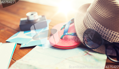 Image of close up of travel map, flip-flops, hat and ticket