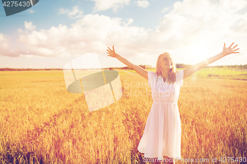 Image of smiling young woman in white dress on cereal field