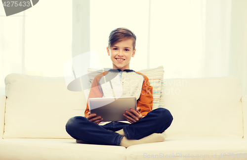 Image of smiling boy with tablet computer at home