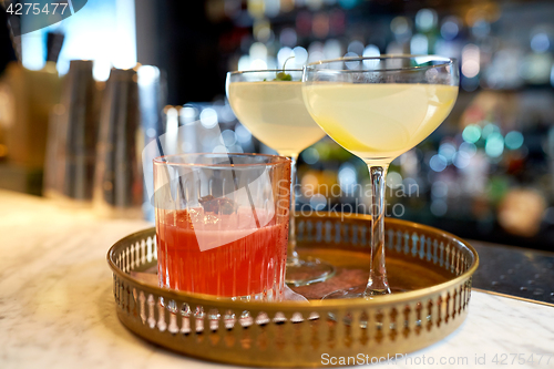 Image of tray with glasses of cocktails at bar