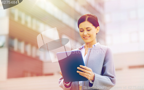 Image of smiling business woman with tablet pc in city