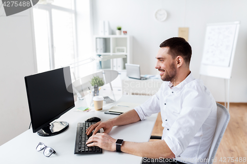 Image of businessman typing on computer keyboard at office