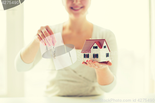 Image of close up of woman holding house model and keys