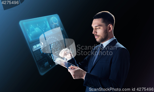 Image of businessman in suit with transparent tablet pc