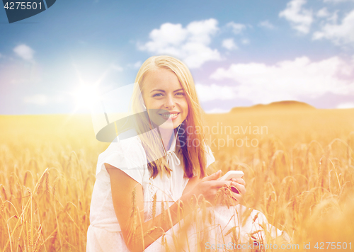 Image of happy woman with smartphone and earphones