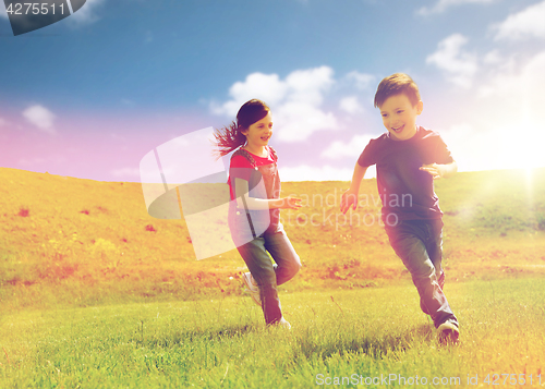 Image of happy little boy and girl running outdoors