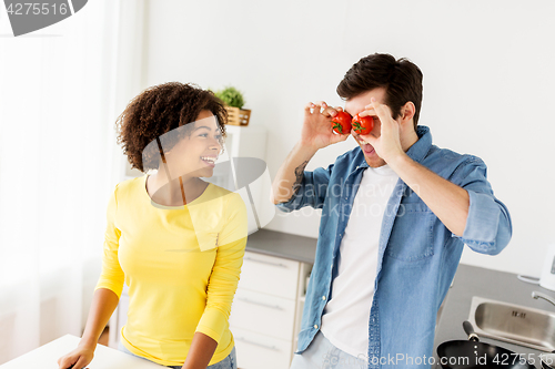 Image of happy couple cooking food and having fun at home