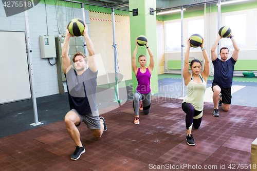 Image of group of people with medicine ball training in gym