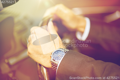 Image of senior businessman hands driving car